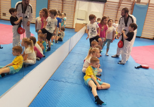 Dzieci trenują dyscyplinę taekwondo na sali AWF